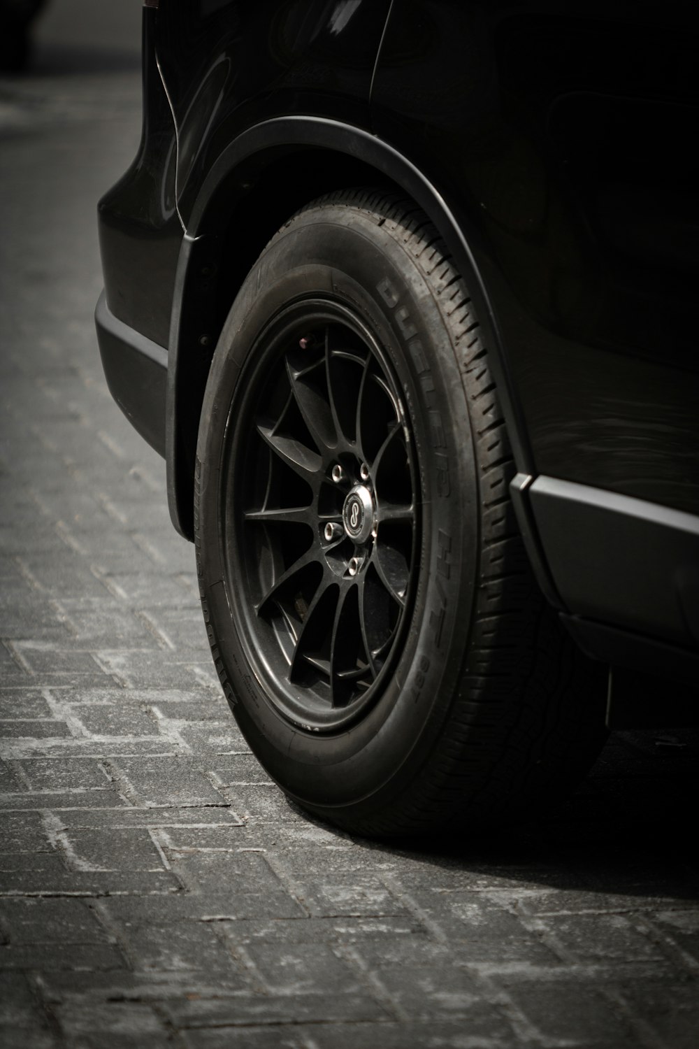 a close up of a car tire on a brick road