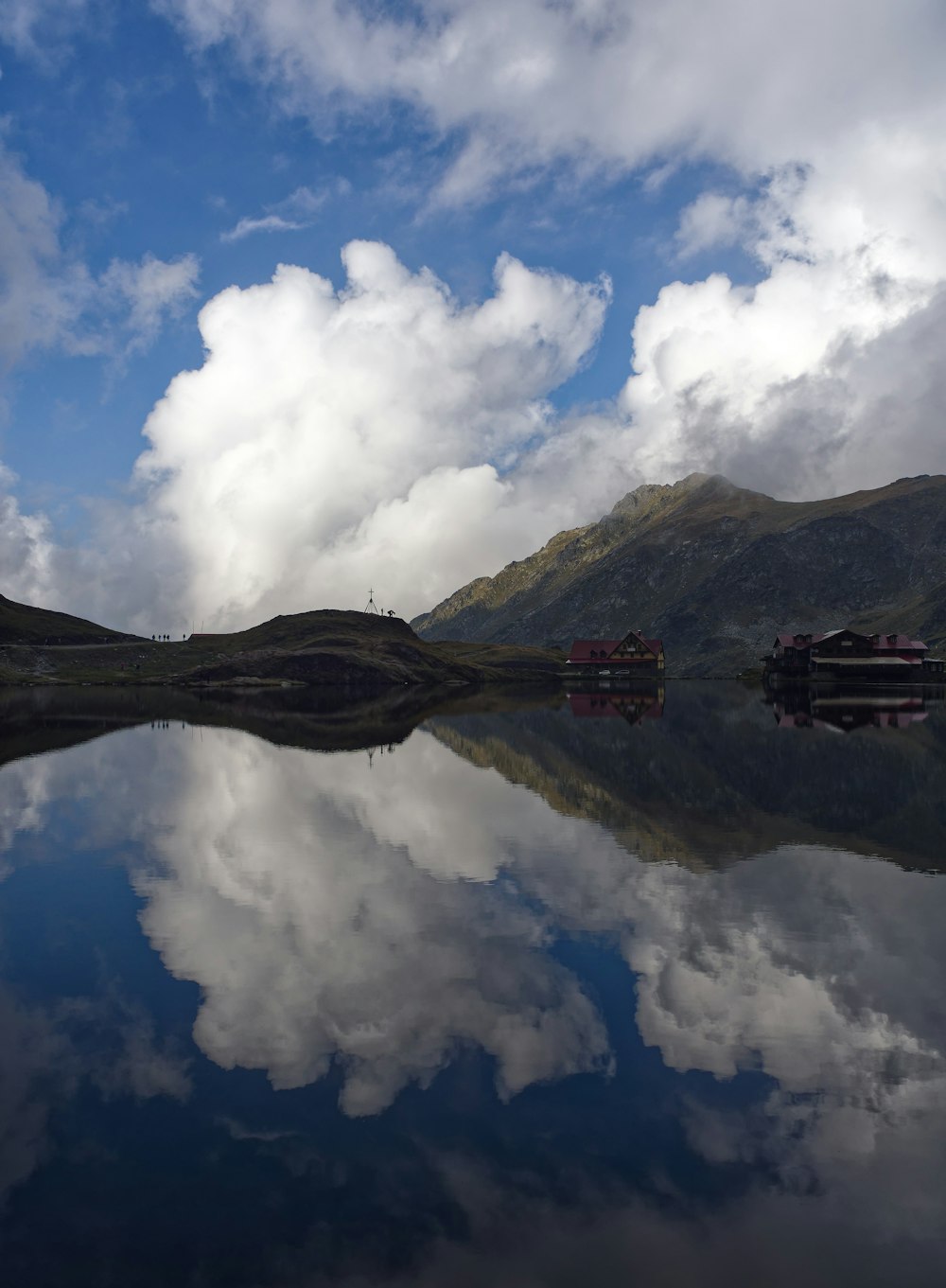 a body of water surrounded by mountains and clouds