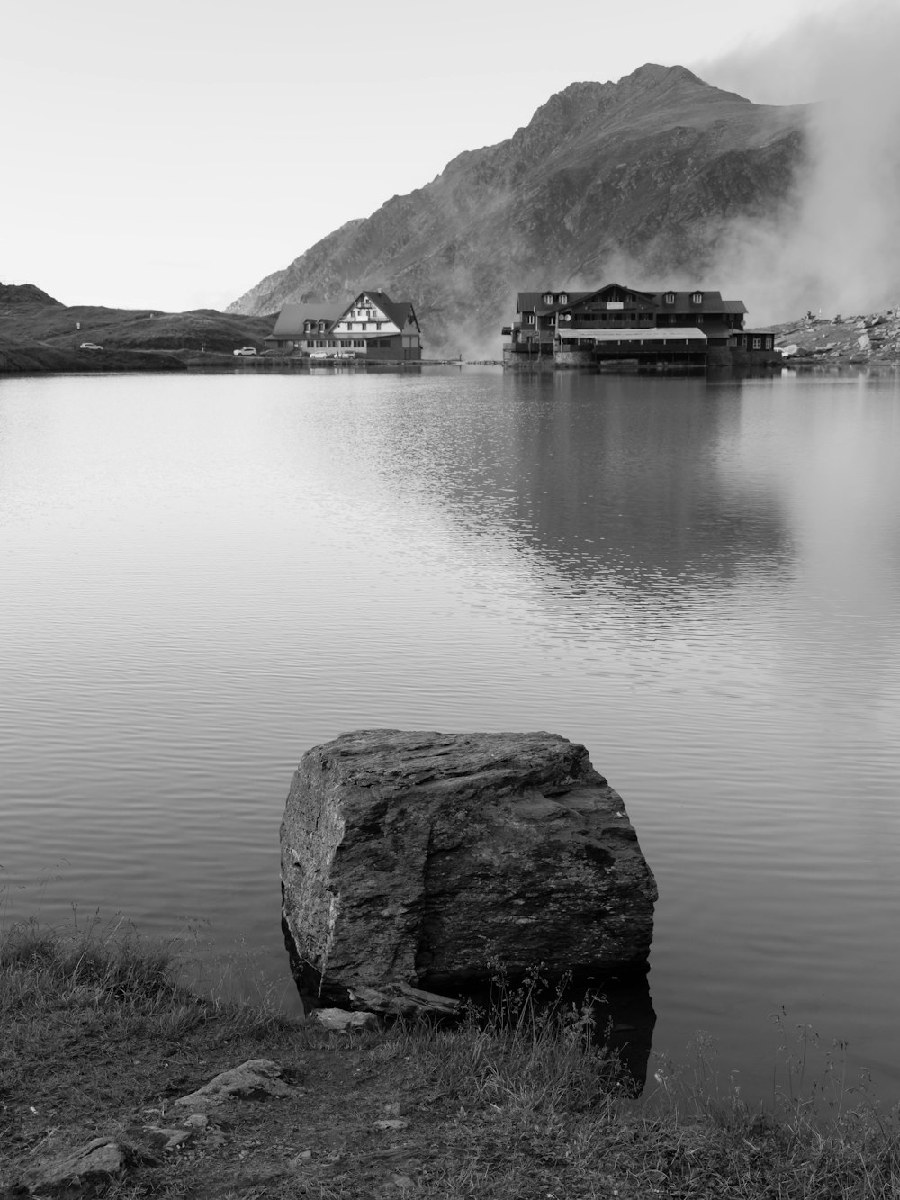 a large rock sitting in the middle of a lake