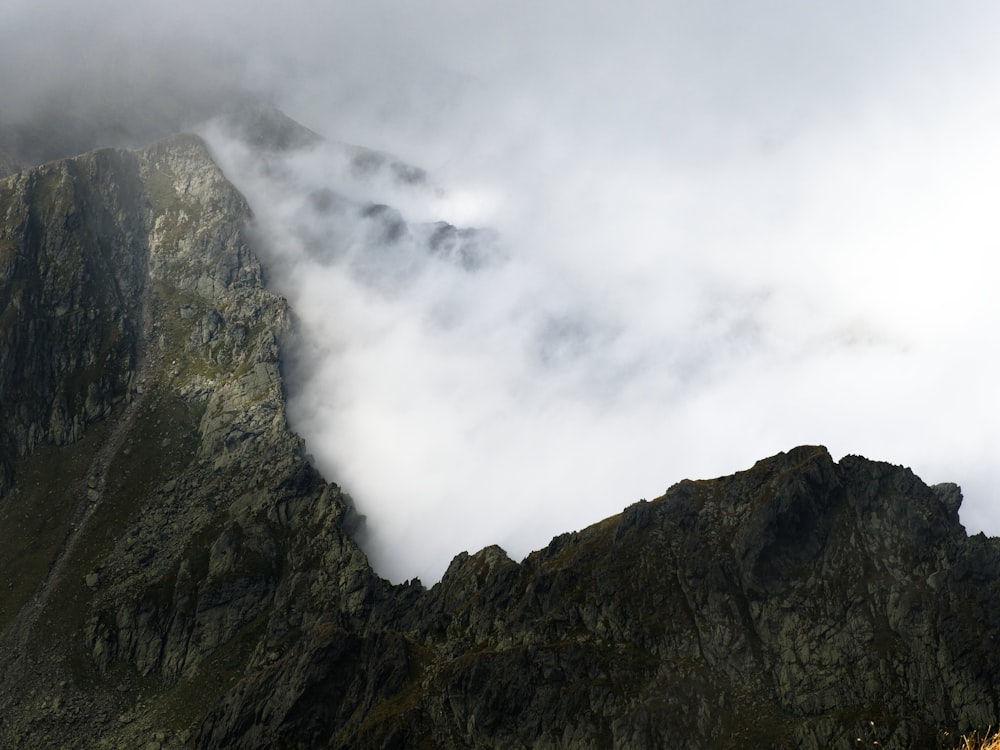 a very tall mountain with some clouds in the air