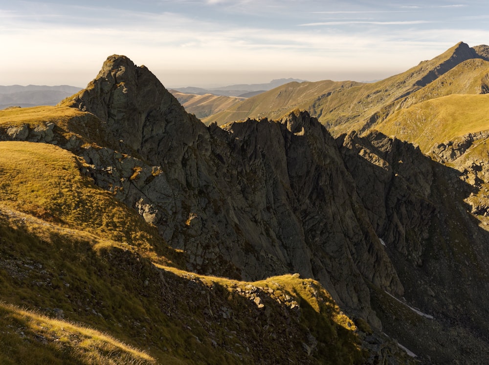 a view of a mountain range from the top of a hill