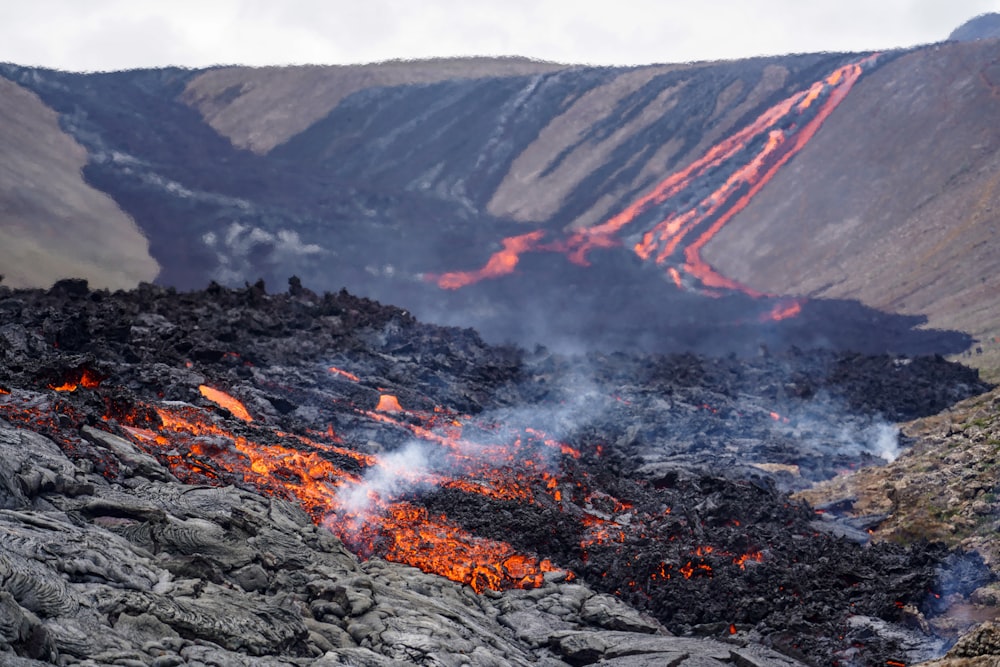 a large amount of lava and rocks with a mountain in the background