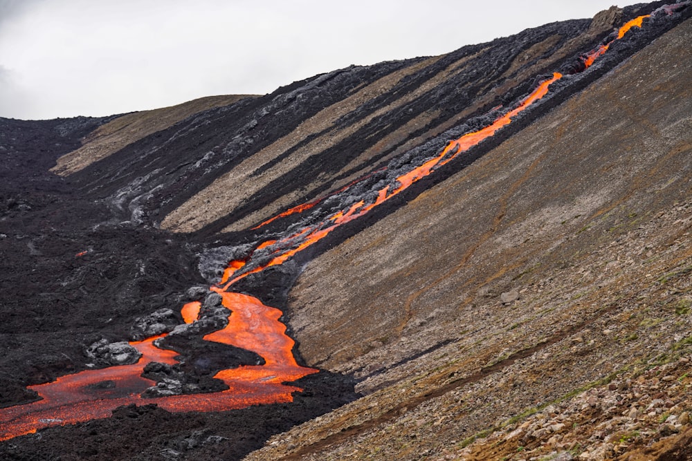 an orange stream of water flowing down a mountain side