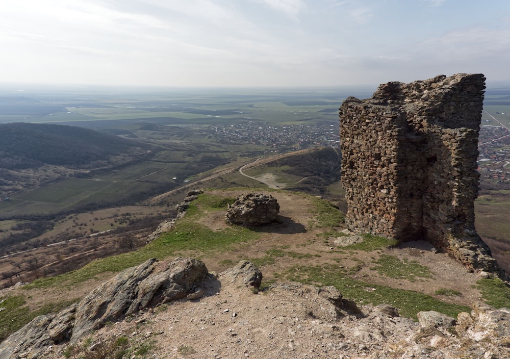 uma torre de pedra sentada no topo de uma colina