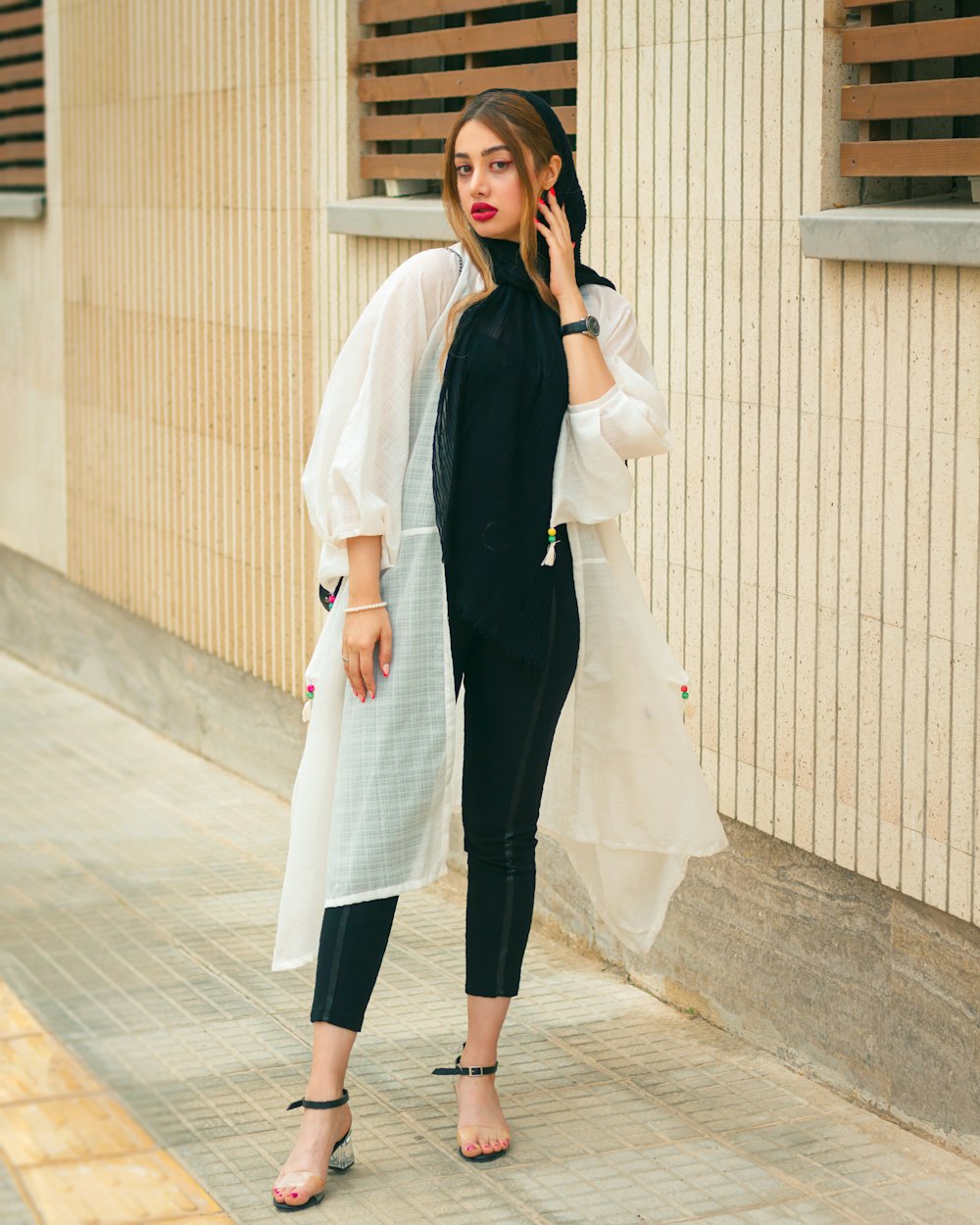 a woman standing on a sidewalk talking on a cell phone