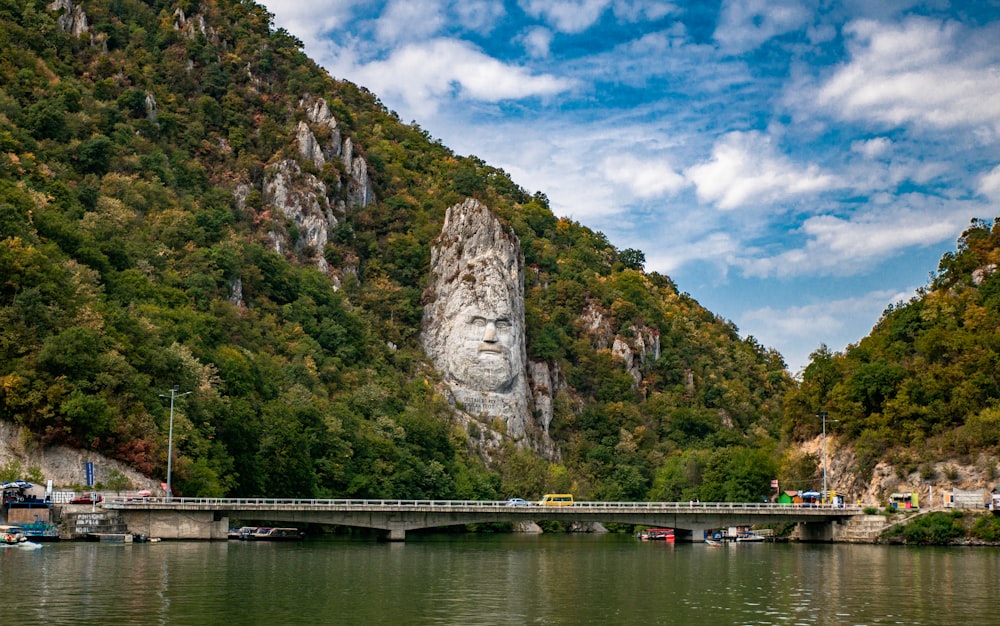 a bridge over a body of water with a mountain in the background