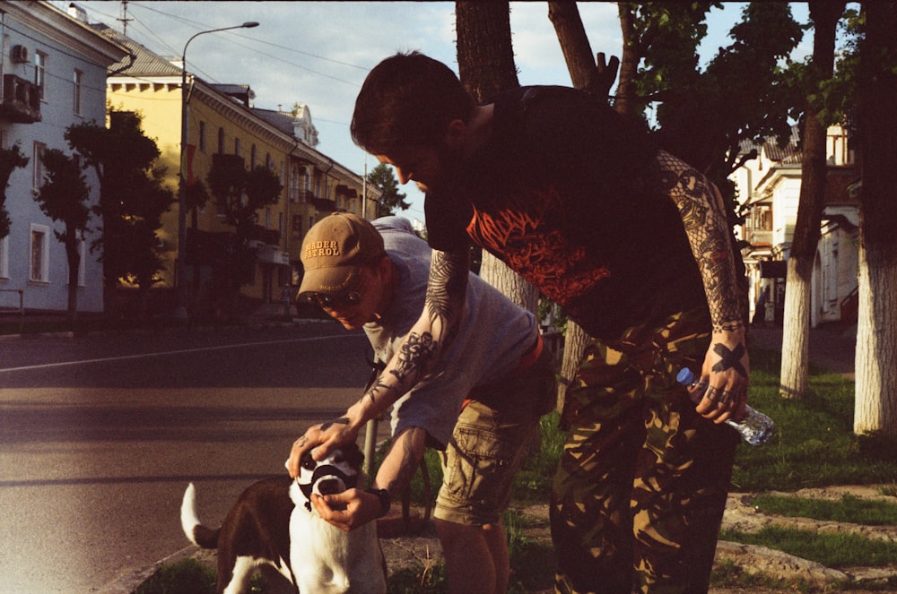 a couple of men standing next to a dog