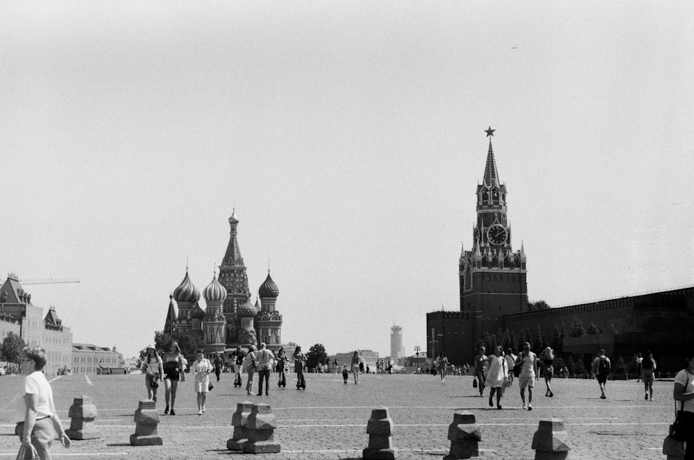 a black and white photo of people walking around a city