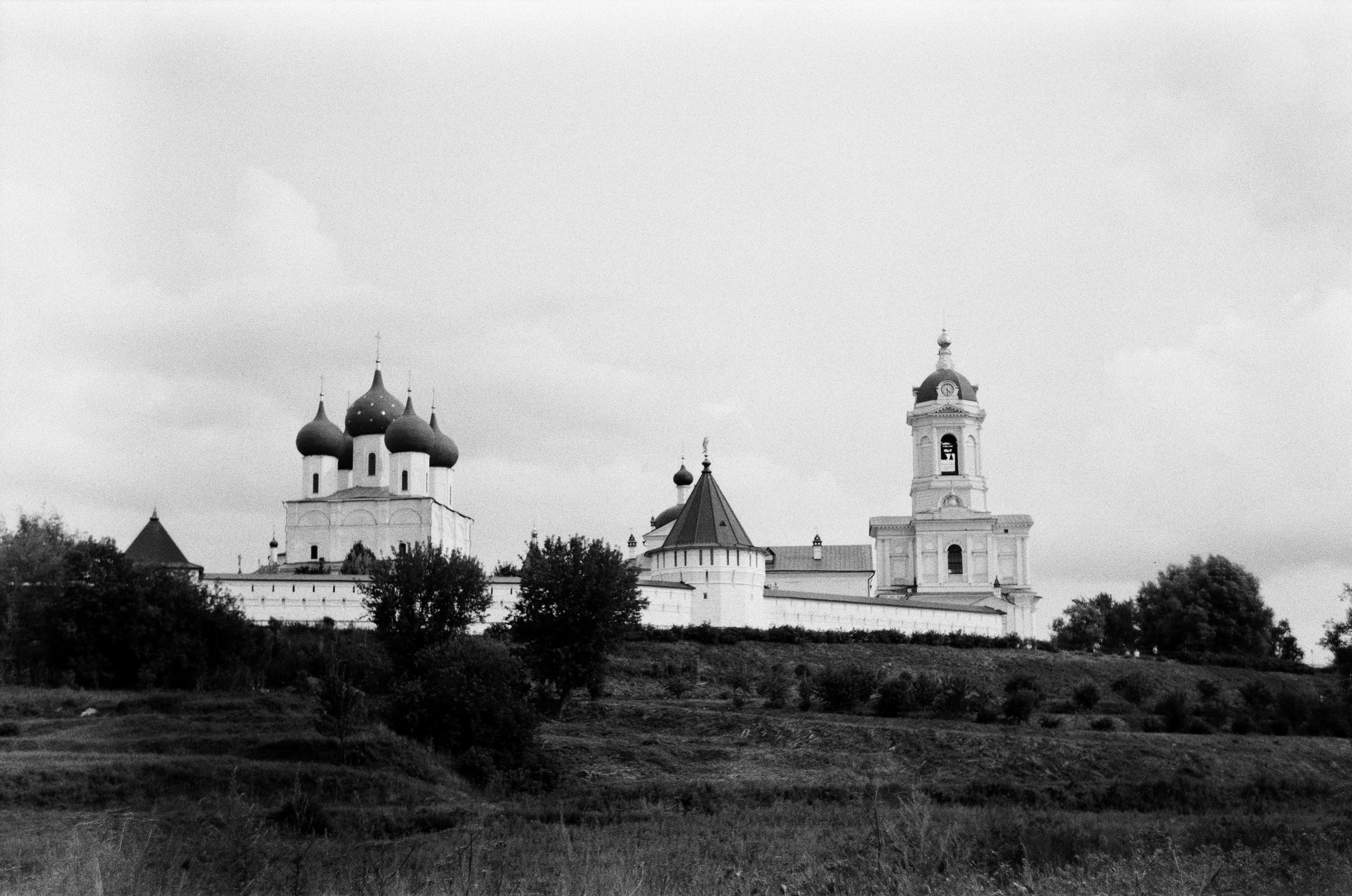 a black and white photo of a church on a hill