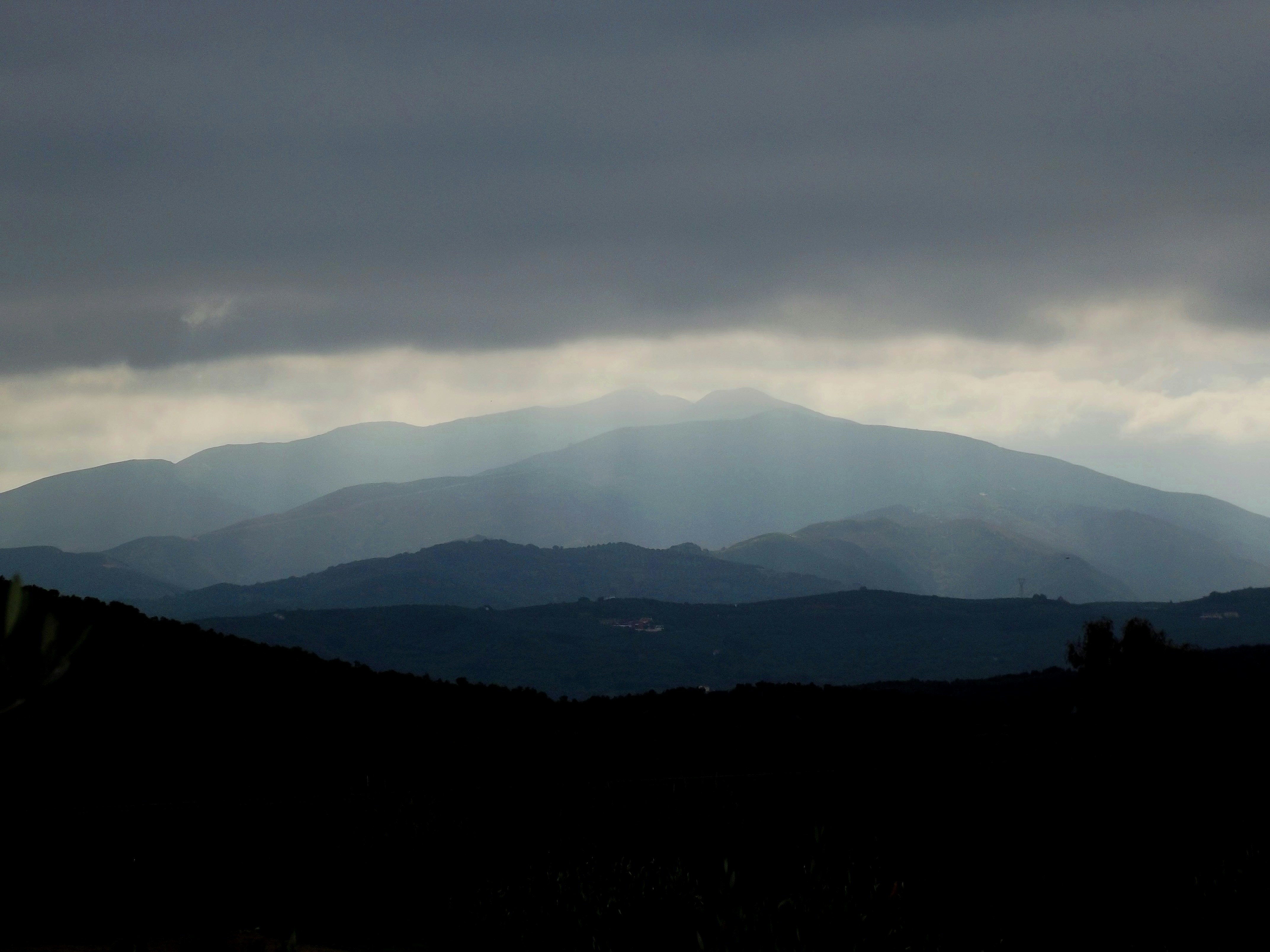 a view of a mountain range under a cloudy sky, 
