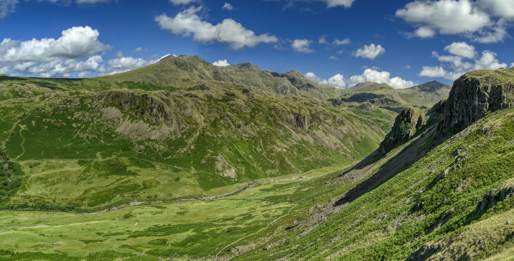 a scenic view of a valley with mountains in the background