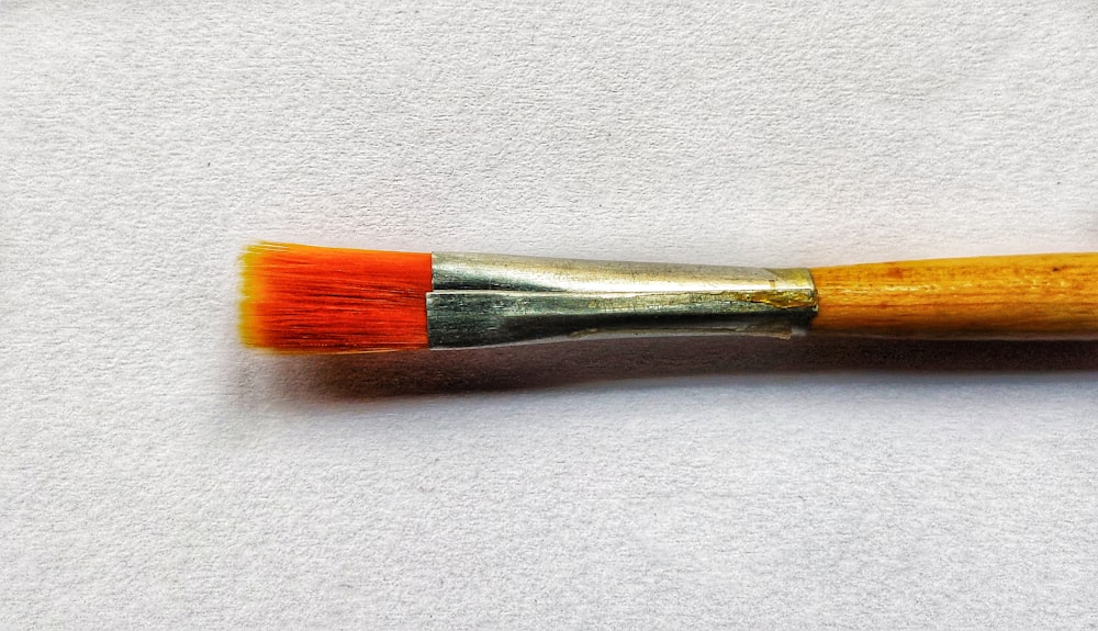 a close up of a paint brush on a white surface