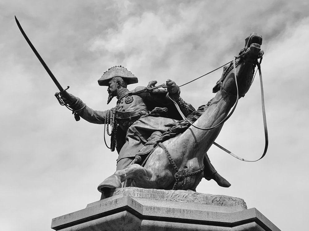 Una foto en blanco y negro de una estatua de un hombre a caballo