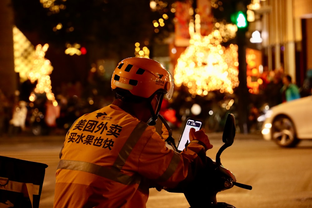 a man on a motorcycle with a cell phone in his hand