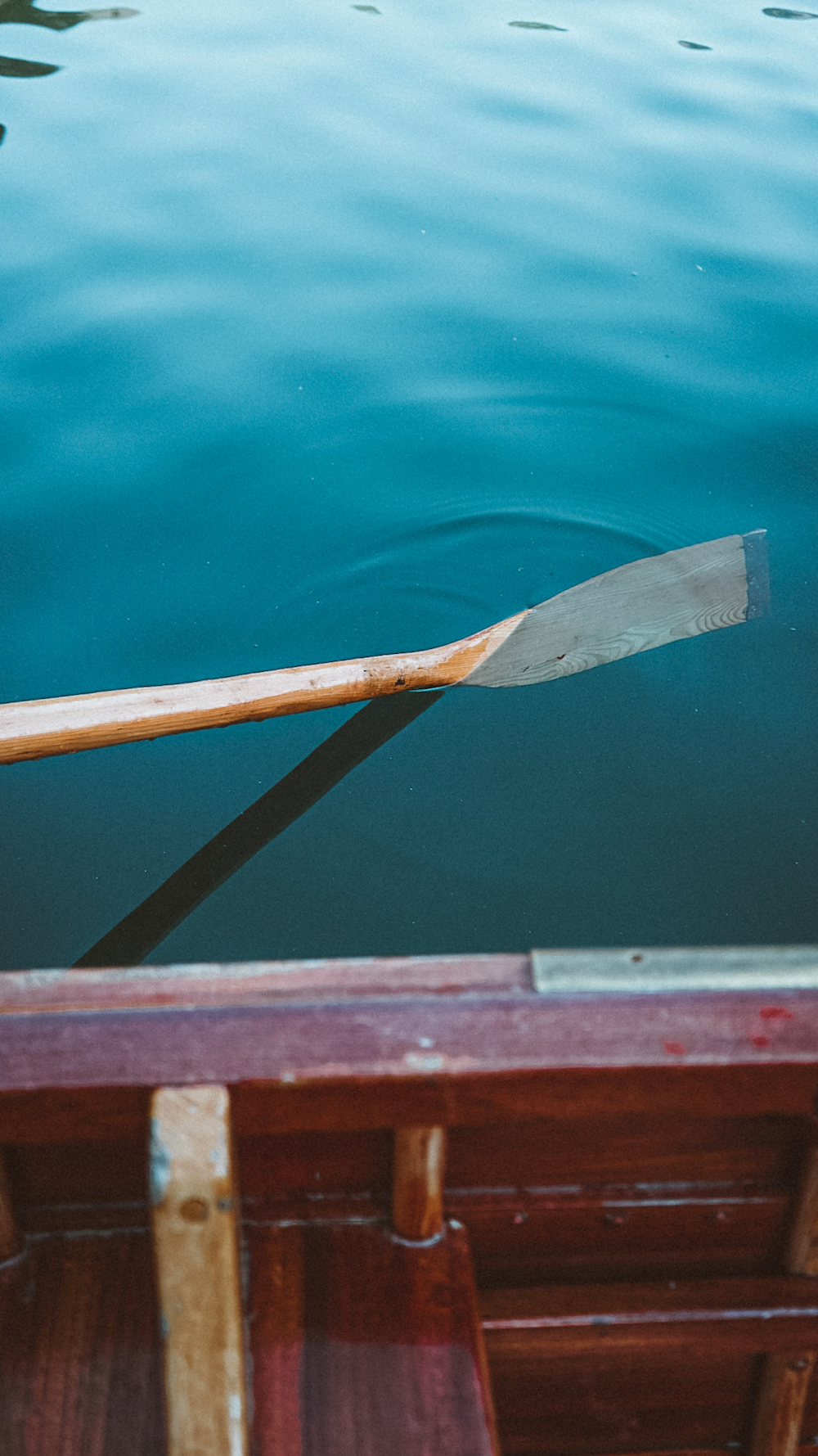 a wooden oar rests on the edge of a boat