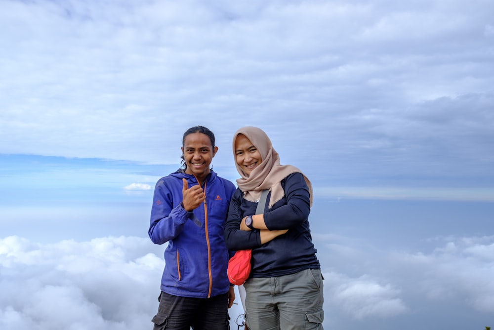 a couple of people standing on top of a mountain