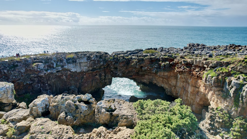 a rocky cliff with a hole in the middle of it