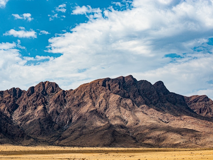a mountain range in the desert under a blue sky