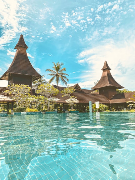 a large swimming pool surrounded by palm trees