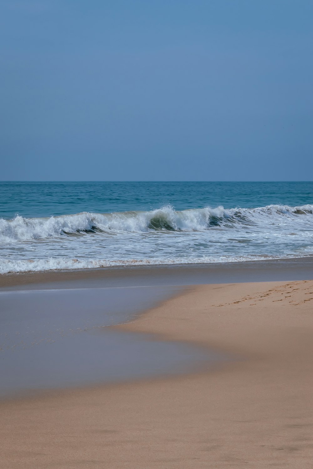 a person walking on the beach with a surfboard