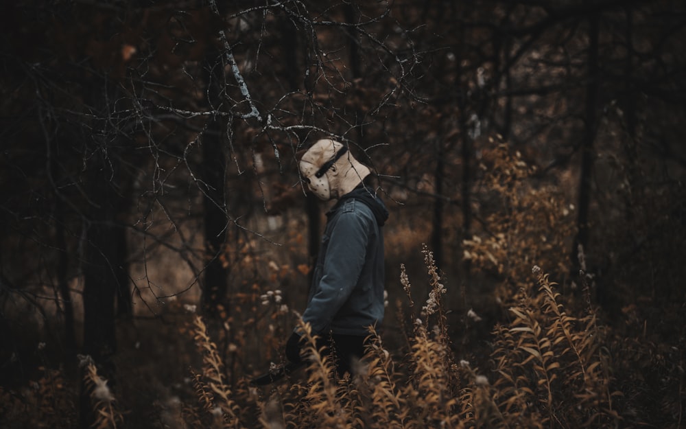 a person walking through a forest with a hat on