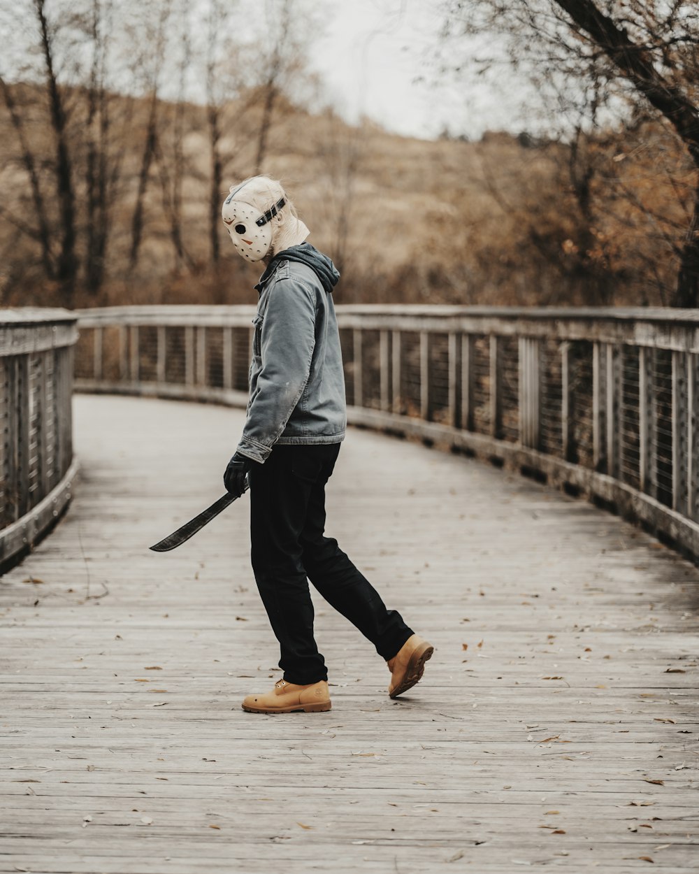 a person walking across a bridge wearing a mask