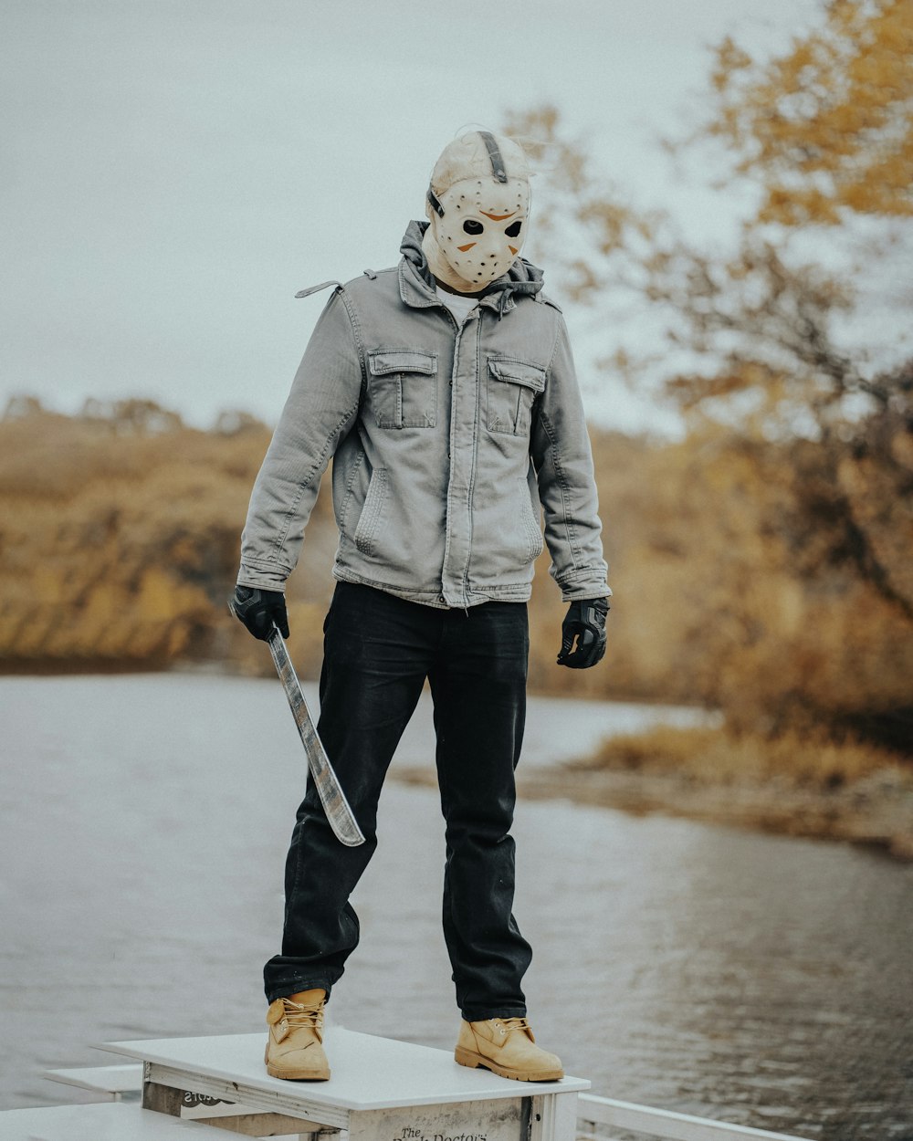 a man wearing a mask standing on a dock