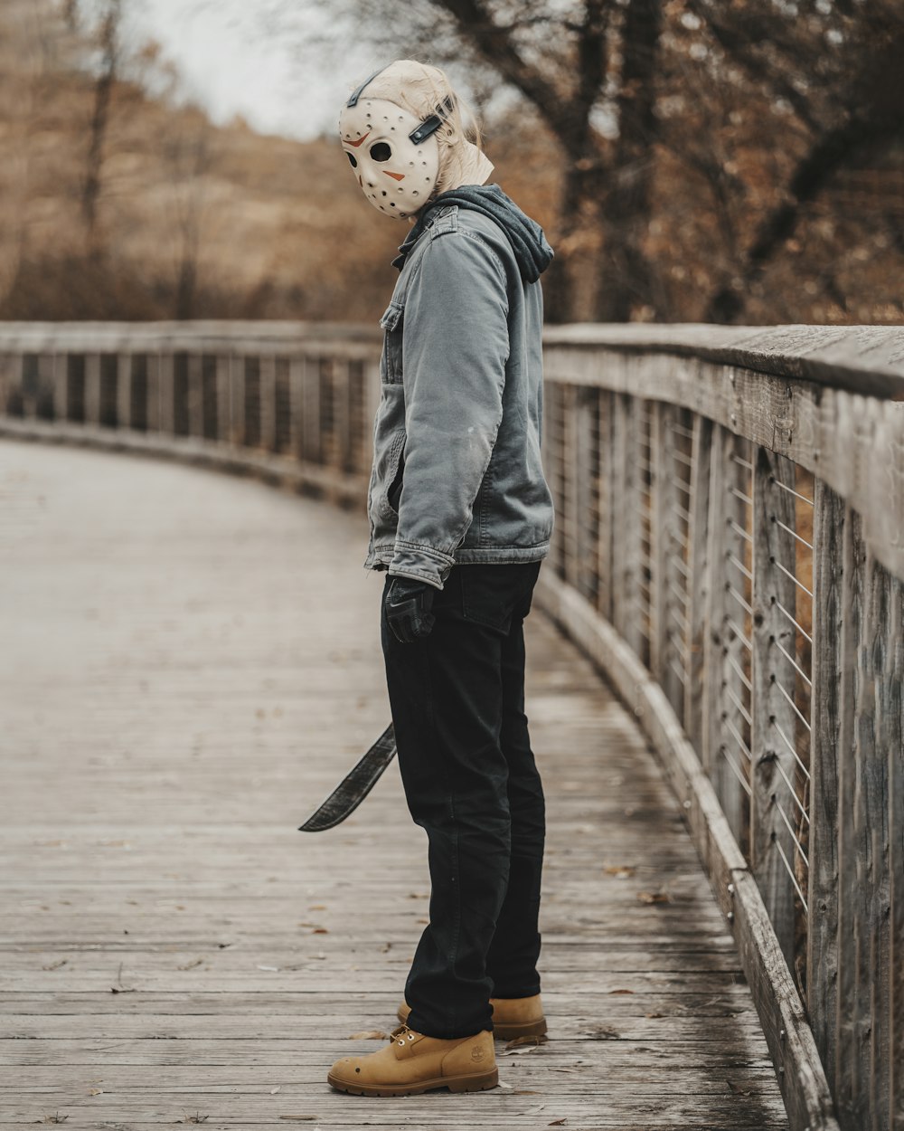 a person standing on a bridge with a mask on