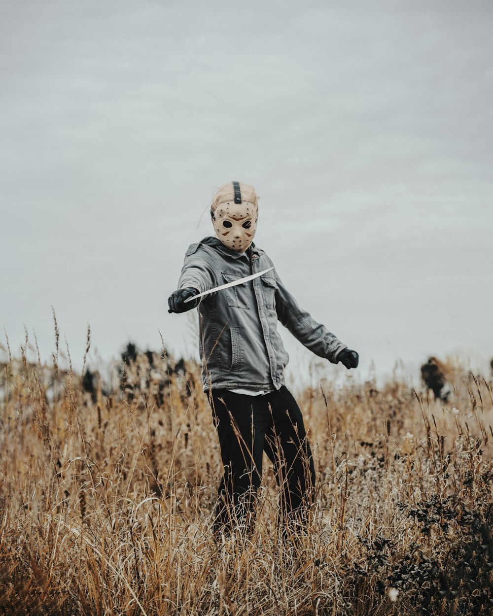 a person wearing a mask standing in a field