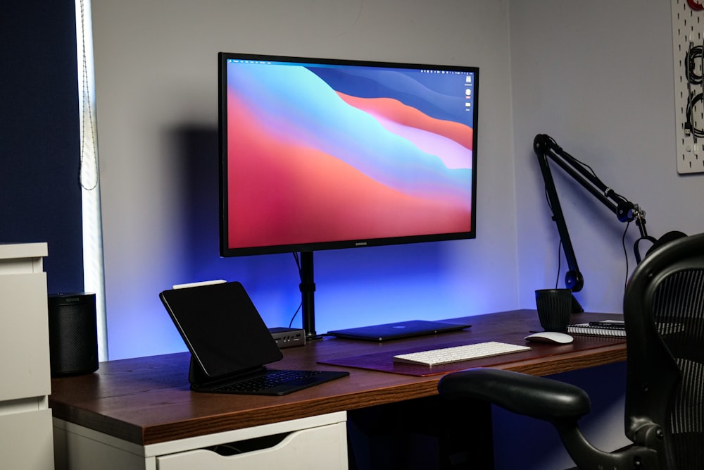 a computer monitor sitting on top of a wooden desk