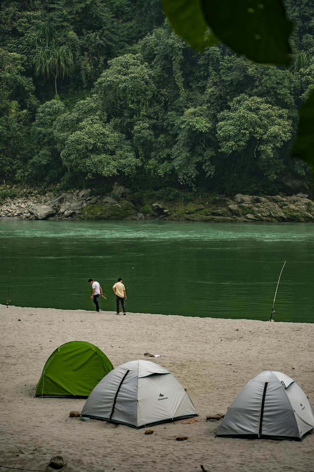 a couple of tents sitting on top of a sandy beach