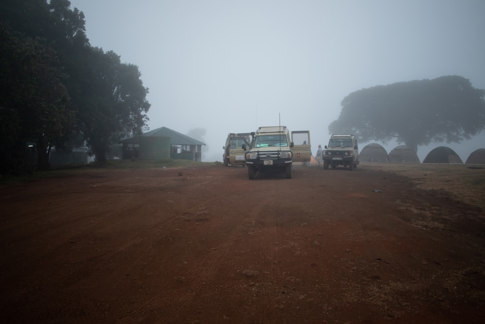 a group of trucks parked on a dirt road