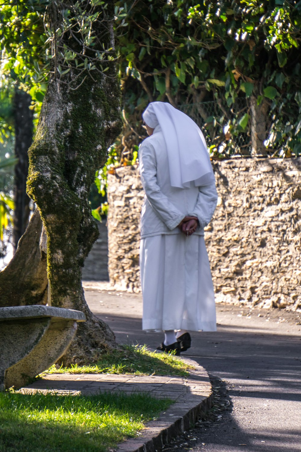 a person in a white robe walking down a street