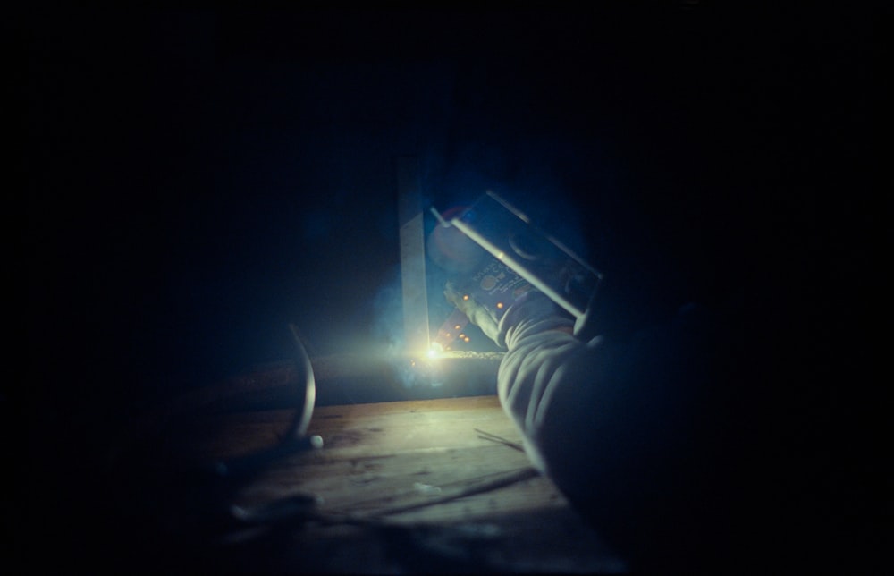 a person holding a flashlight in a dark room