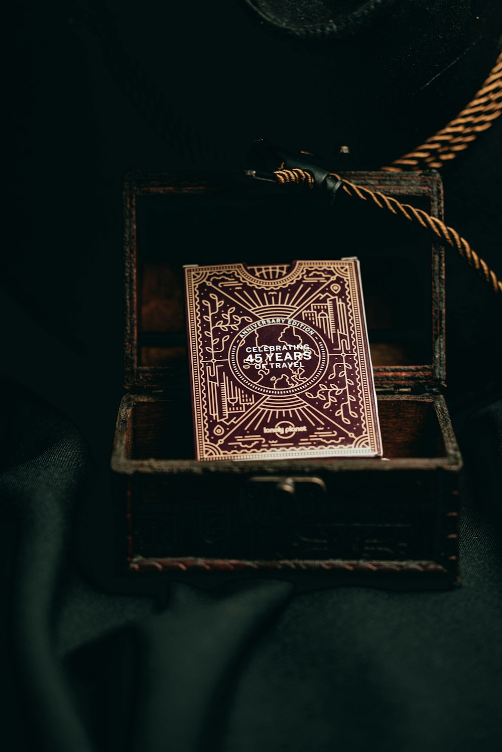 a playing card in a wooden box on a black background