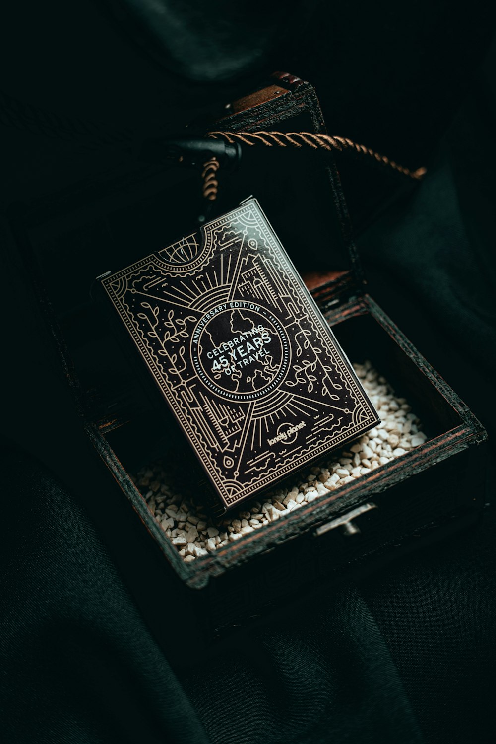 a playing card in a wooden box on a black background