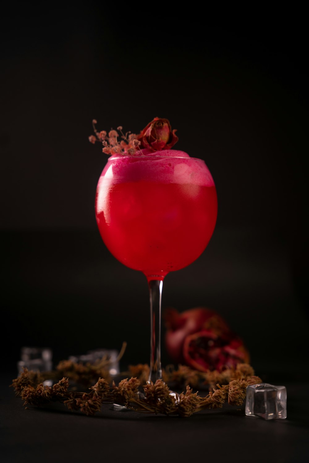 a red cocktail with a garnish garnish on top of it