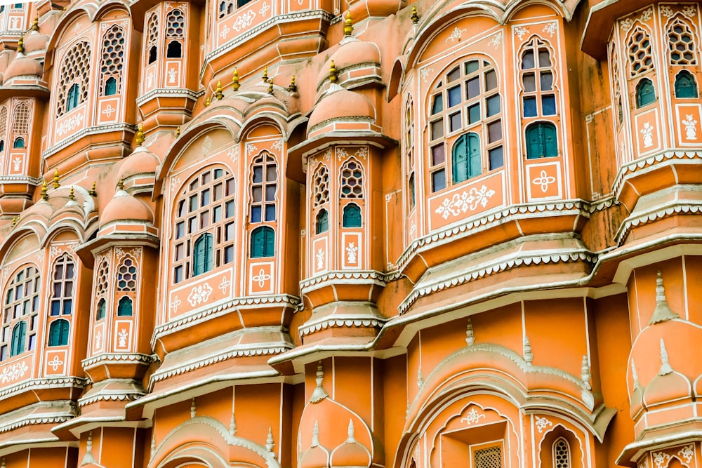 ein großes orangefarbenes Gebäude mit vielen Fenstern und Bögen