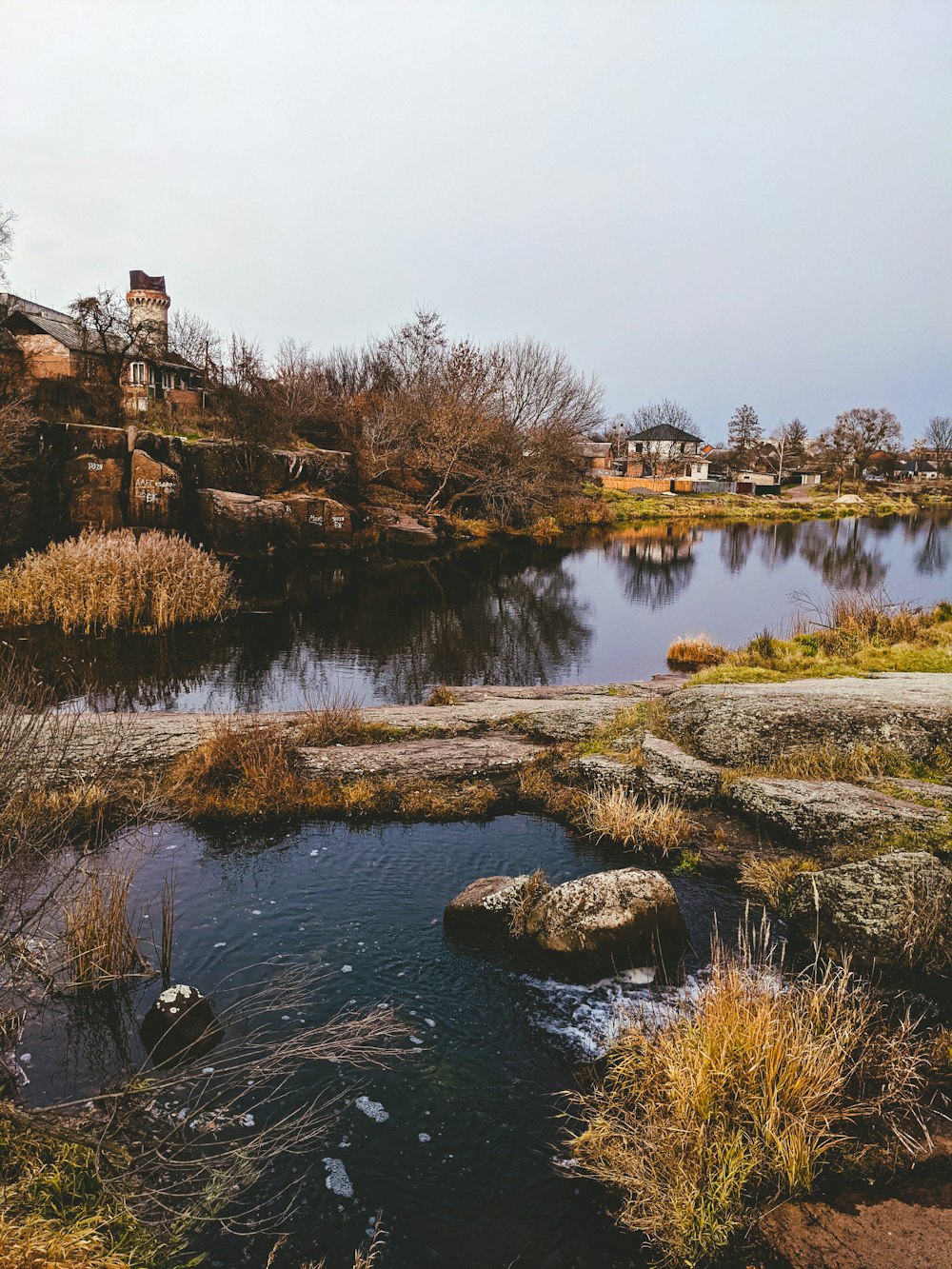 a small pond surrounded by rocks and grass