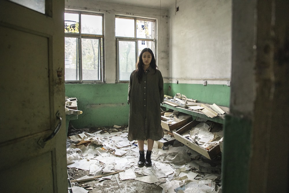 a woman standing in a room full of papers