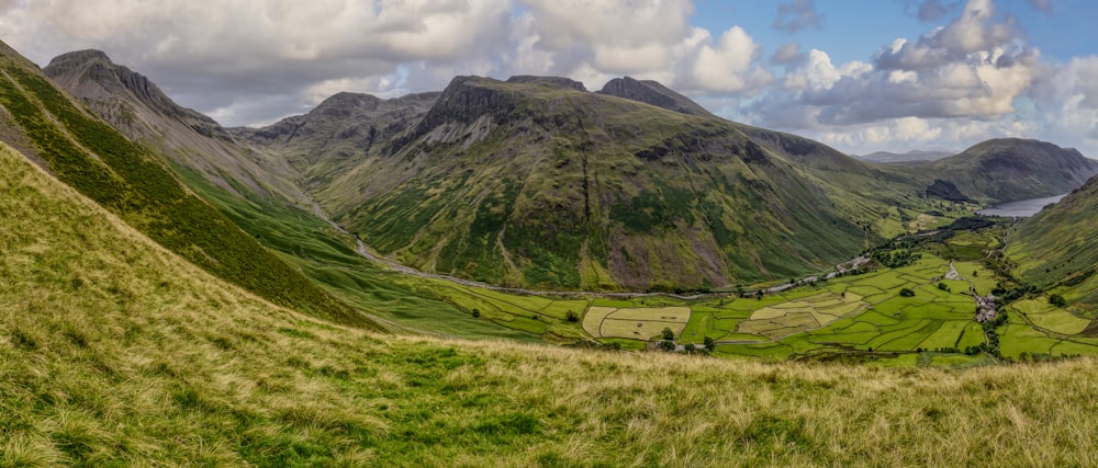 a scenic view of a valley with mountains in the background