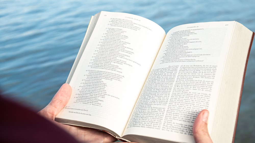 a person holding an open book in their hands