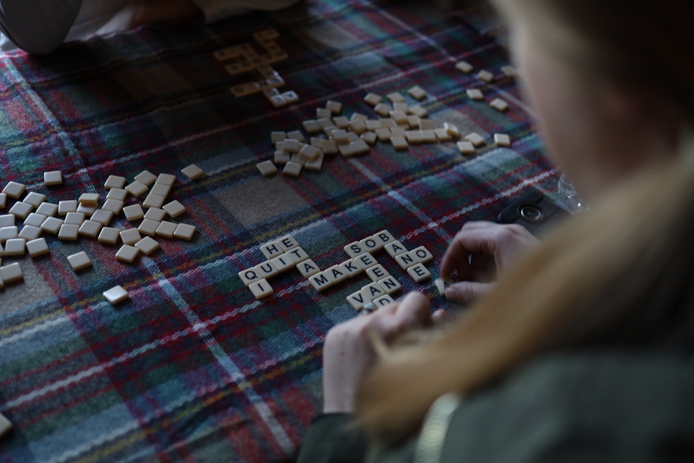 a woman playing a game of scrabble on the floor