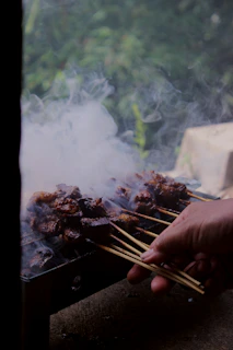 a person is cooking food on a grill