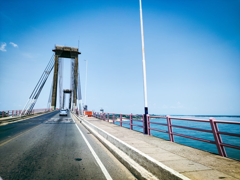 a car driving on a bridge over a body of water