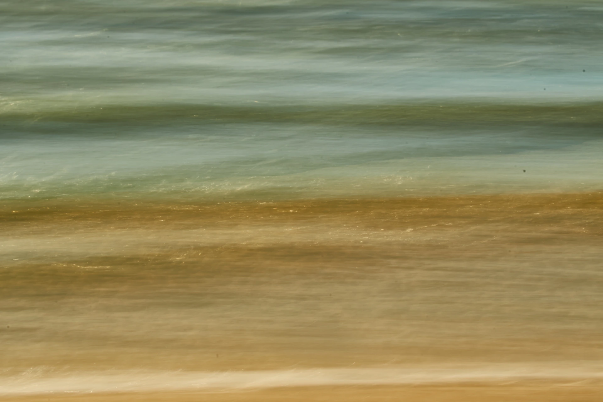 a blurry photo of the ocean and sand