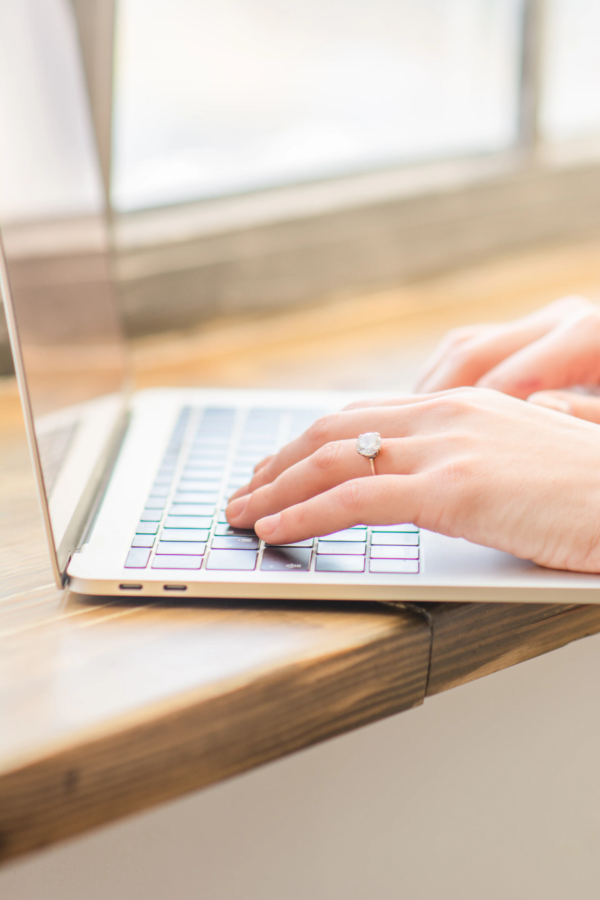 a woman's hand on a laptop keyboard