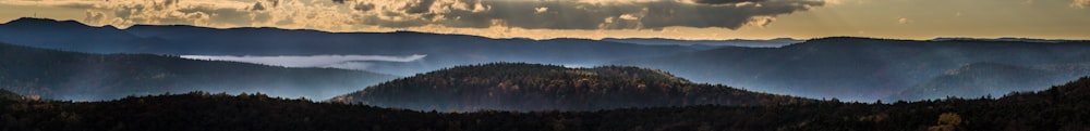 a view of a mountain range with clouds in the sky