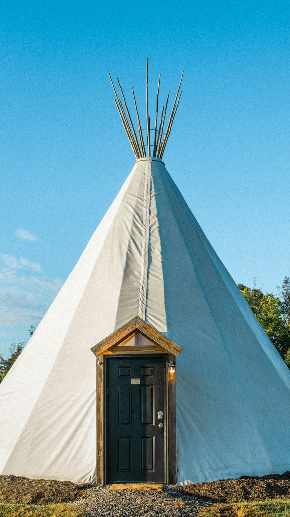 un grand tipi blanc avec une porte devant lui