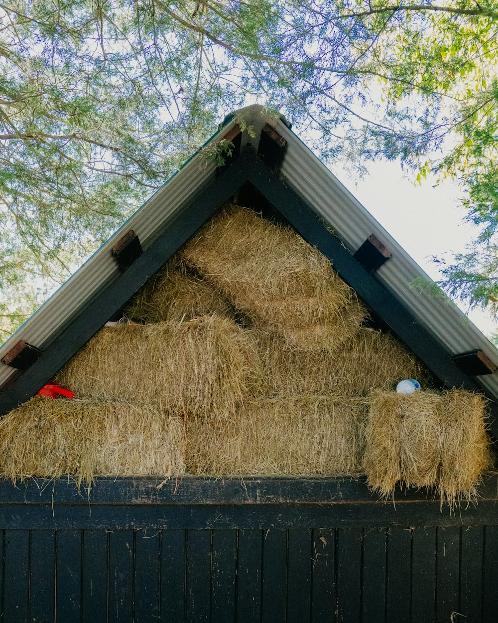 a pile of hay sitting on top of a wooden fence